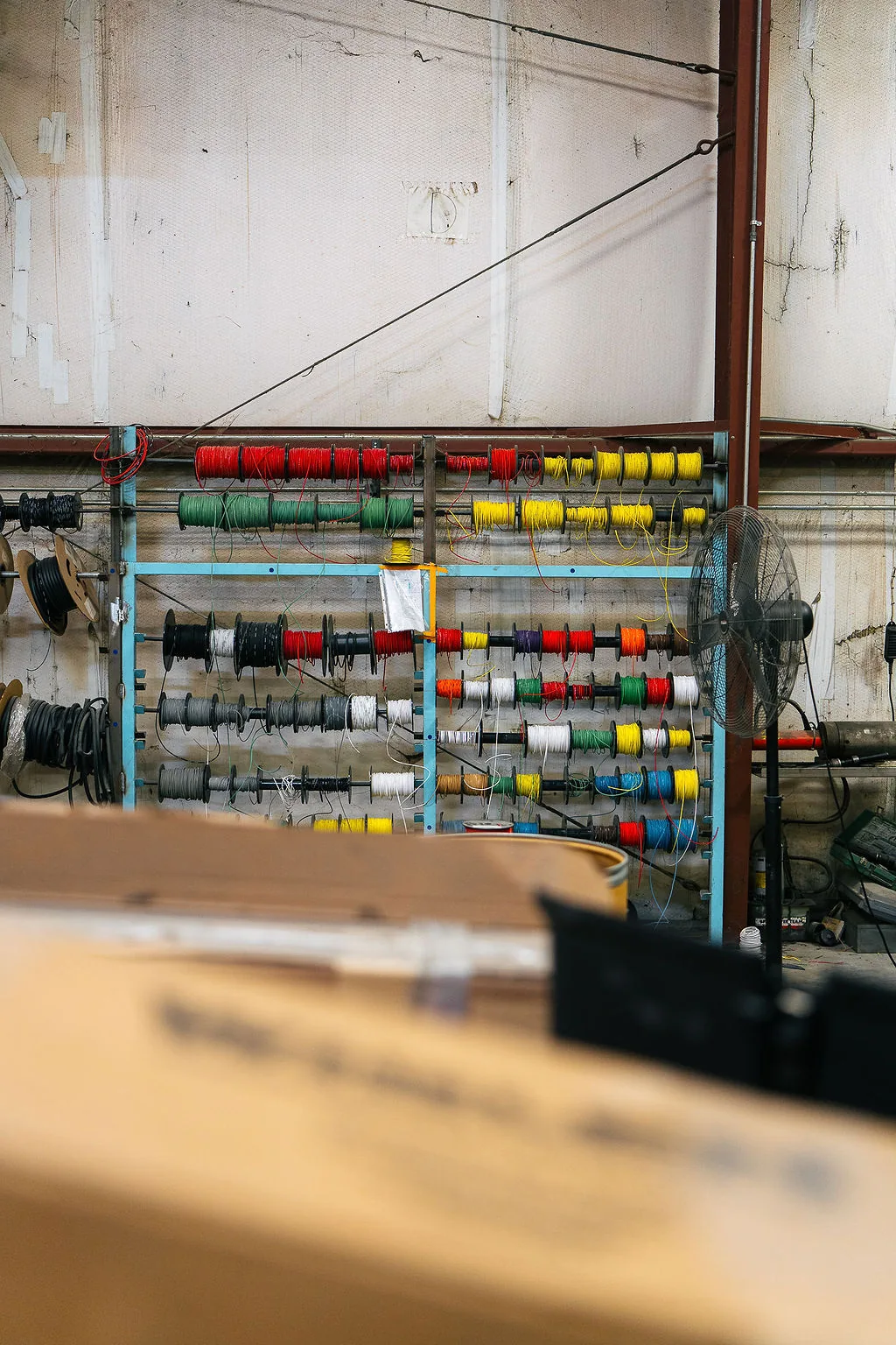 Color coded electrical wire spools racked for harness work in the FES shop